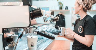 A female barista working behind a La Marzocco GB5 at Artisti Coffee Roasters on the Coffs Coast.