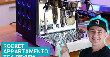 Luke Floyd from Artisti Coffee Roasters in front and pointing at a Rocket Espresso Appartamento TCA home coffee machine.