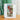 Silver 13.5g Artisti coffee drip bag featuring a Burundi coffee cherry illustration on a wooden table.