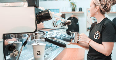 A female barista working behind a La Marzocco GB5 at Artisti Coffee Roasters on the Coffs Coast. 