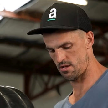 Collingwood AFL player Scott Pendlebury wearing an Artisti Coffee Roasters truckers cap. 